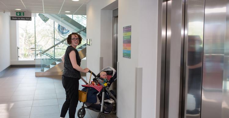 Woman pushing a buggy into a lift