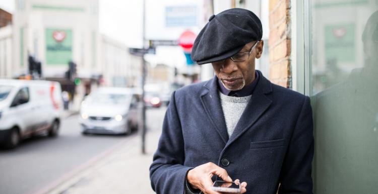 man on phone on the sidewalk