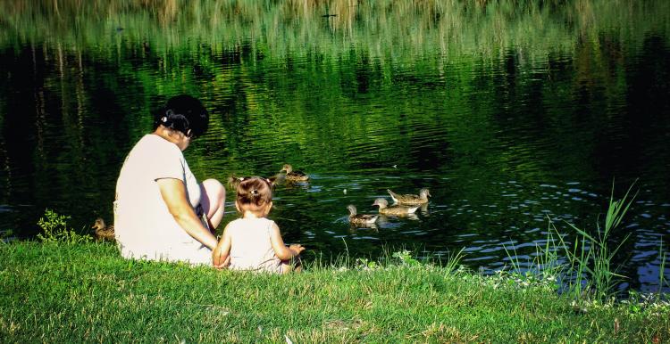 woman with baby by lake woman with baby by lake