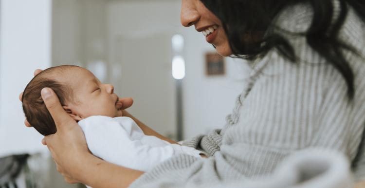 smiling woman holding her baby smiling woman holding her baby