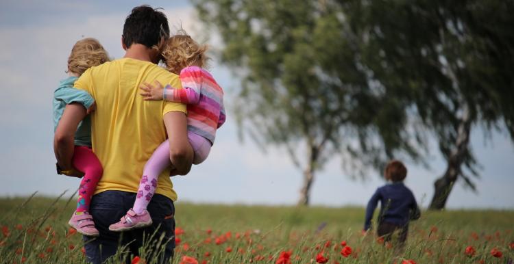 Father walking in park with kids in his arms Father walking in park with kids in his arms