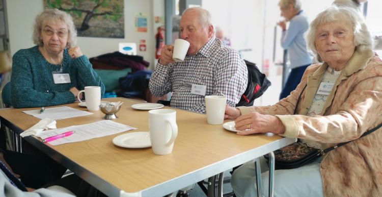Elderly people sitting around a table drinking tea Elderly people sitting around a table drinking tea