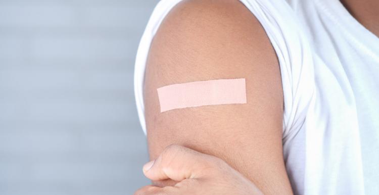 person with band aid on arm after receiving vaccination