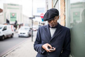 man on phone on the sidewalk