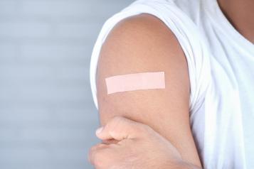 person with band aid on arm after receiving vaccination